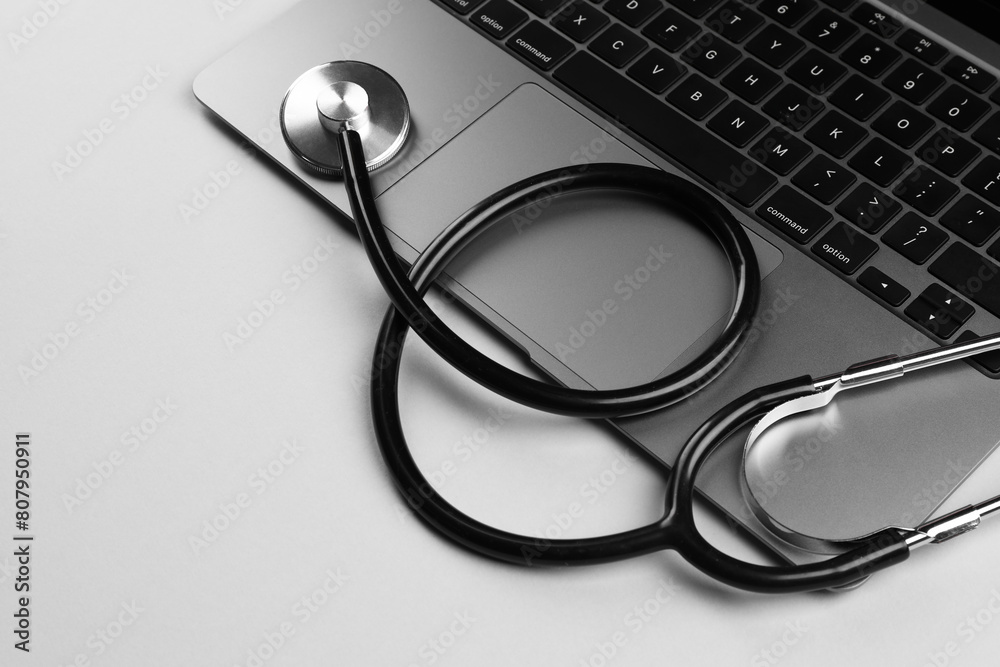 Laptop and stethoscope on light grey background. Space for text Laptop and stethoscope on light grey background. Space for text