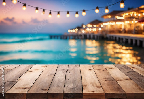 Seaside Serenity, Wooden Table Overlooking Beach Cafes with a Dreamy Bokeh Lights Background photo