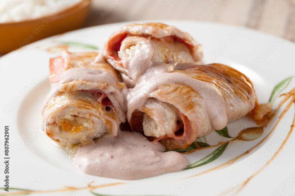 Three turkey steaks stuffed and rolled ham and cheese gratin in oven Three turkey steaks stuffed and rolled ham and cheese gratin in oven
