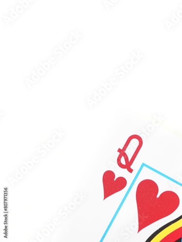 Close up of a Queen of hearts poker playing card in a corner on a white background with space for text