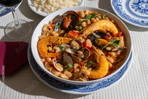 Fototapeta Naklejka Na Ścianę i Meble -  A traditional Alentejo restaurant serves a vibrant seafood feijoada. This dish features prawns, shellfish, and beans in a rustic clay pot, offering a hearty and authentic Portuguese experience.