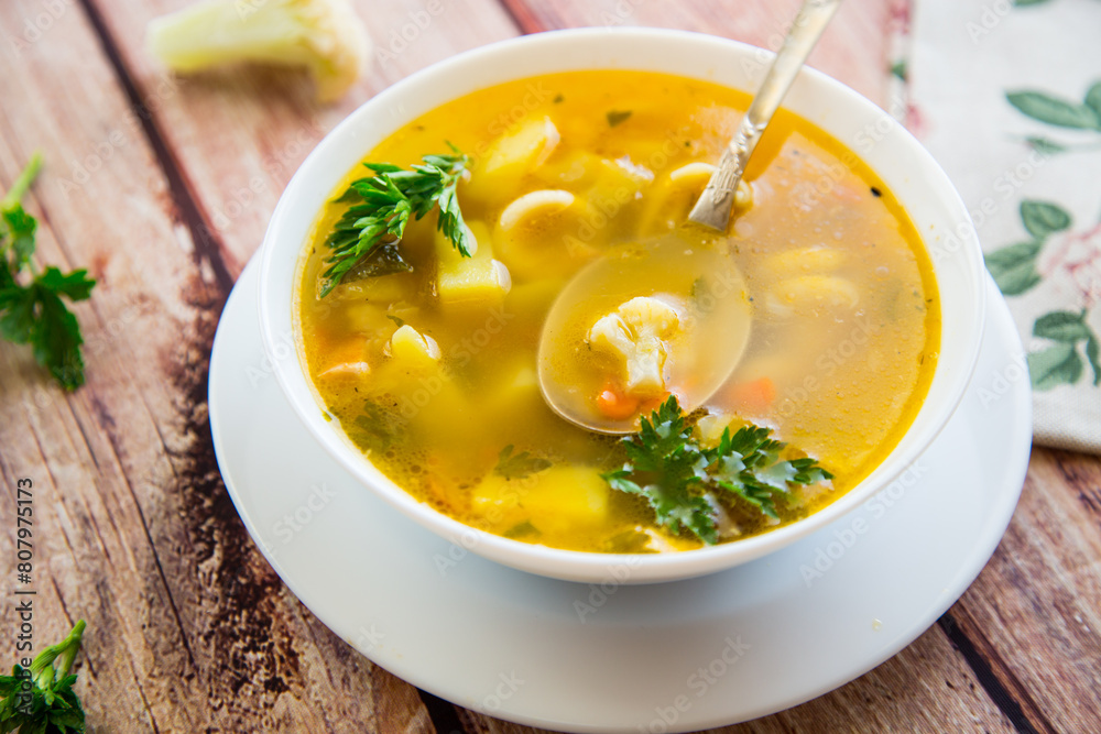 Homemade chicken vegetable soup on rustic wooden background Homemade chicken vegetable soup on rustic wooden background