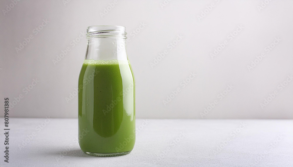 Refreshing green smoothie in glass bottle on table. Healthy and tasty drink. Delicious beverage. Refreshing green smoothie in glass bottle on table. Healthy and tasty drink. Delicious beverage.