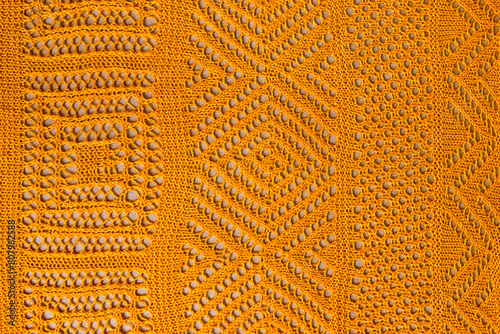 Textured orange openwork close-up crocheted. Orange patterned background photo