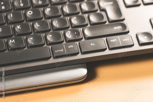 Wireless keyboard with laptop on yellow background.