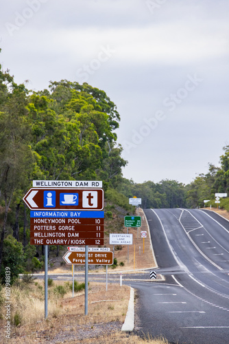 Wellington Dam Road turnoff on highway with many signs at the intersection photo