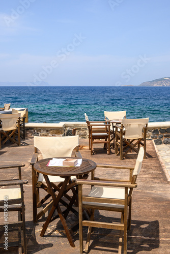 Tables and chairs in typical Greek seaside restaurant on Nisyros island. Greece