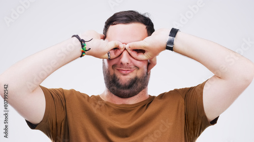 Tableau sur toile Studio, man and binoculars with hands for crazy comic, silly and goofy expression with smile