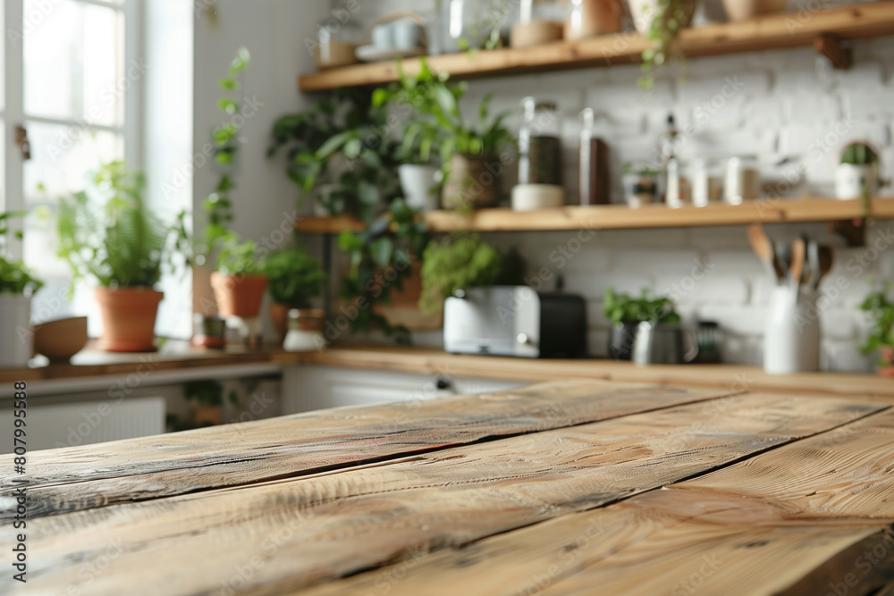 Wooden table in focus with a blurred modern kitchen background filled with green plants and white shelves. Wooden table in focus with a blurred modern kitchen background filled with green plants and white shelves.