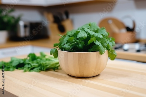 Fresh cilantro in a wooden bowl on a kitchen counter, with more herbs scattered in the background