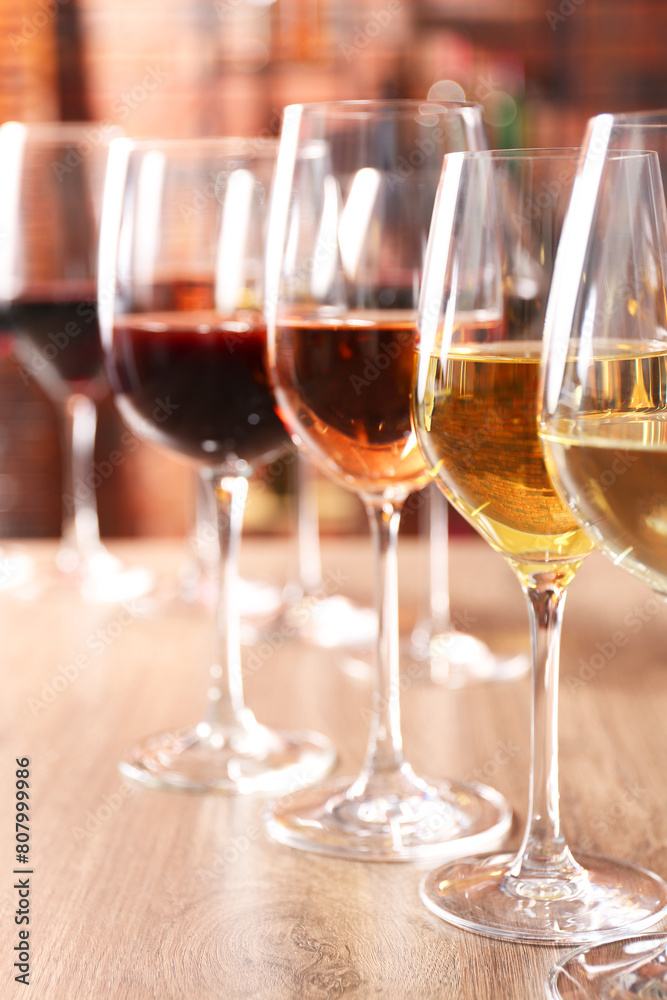 Different tasty wines in glasses on wooden table