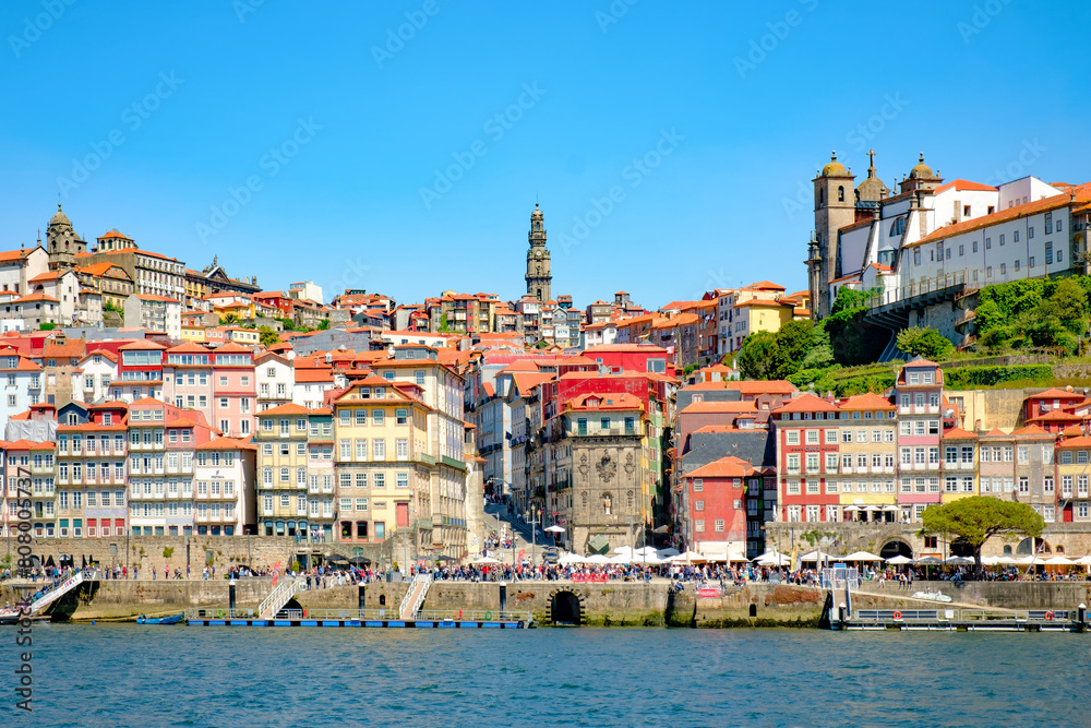 A photograph of the city of Porto intended for tourism on a sunny day. Concept: A city with traditional Portuguese architecture on the banks of the Douro River.