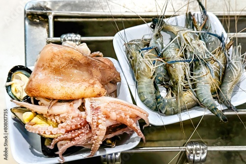 Assorted raw seafood including prawns, squid and octopus on take away containers at street food stall, appealing to adventurous eaters and highlighting trend towards diverse, ocean-fresh diets photo