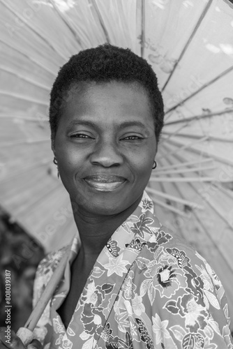 monochome portrait of young adult short haired african woman dressed in vintage kimono and parasol photo