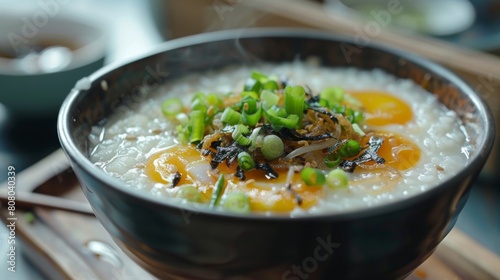 A traditional Chinese congee breakfast topped with century eggs and scallions photo