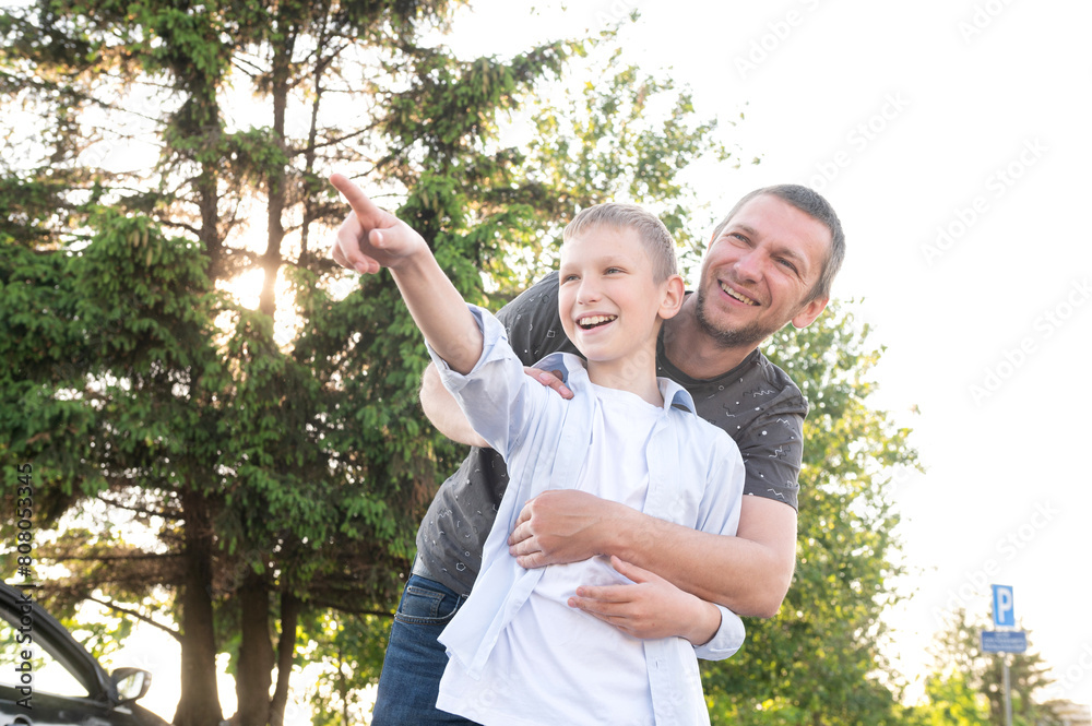 Happy dad hugs his son. Pointing your finger to the side, the contour light