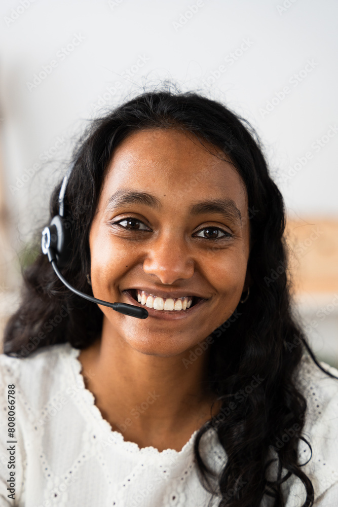 Vertical portrait of Indian call centre worker wearing headset and looking at camera. Vertical portrait of Indian call centre worker wearing headset and looking at camera.