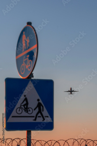Lotnisko w Warszawie i przelatujący startujący samolot przelatujący nad ogrodzeniem lotniska