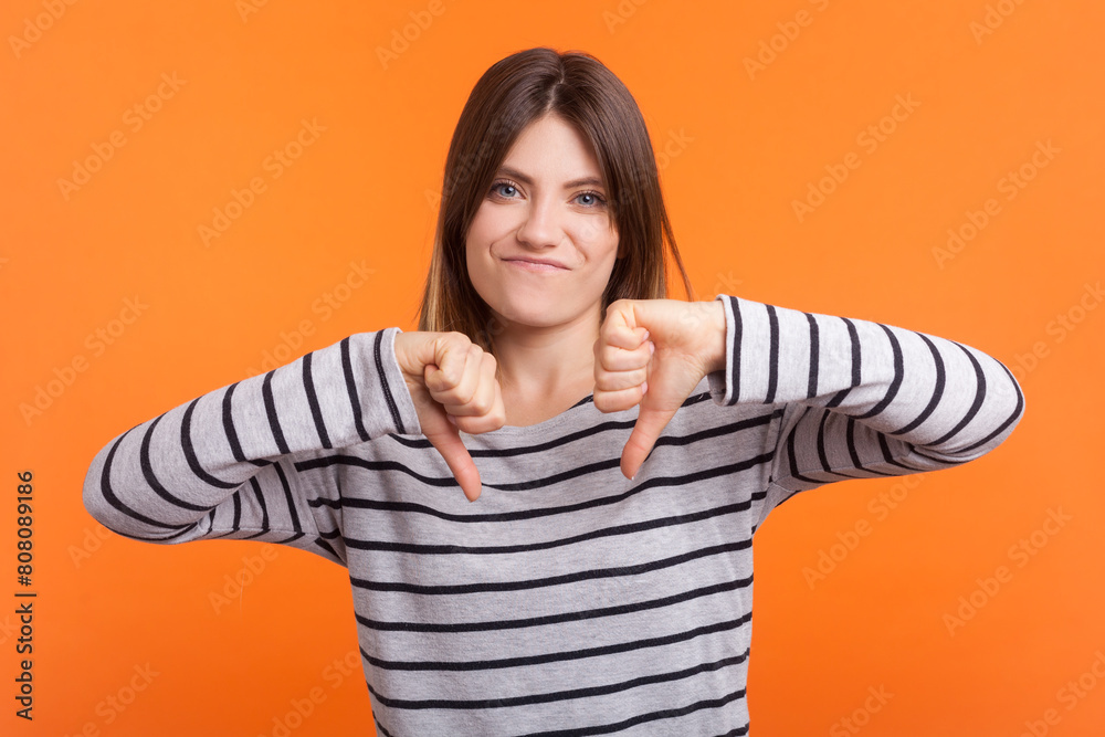 Φωτογραφία Portrait of frustrated sad woman with brown hair showingdisapproval gesture, dislike sign, wearing striped shirt