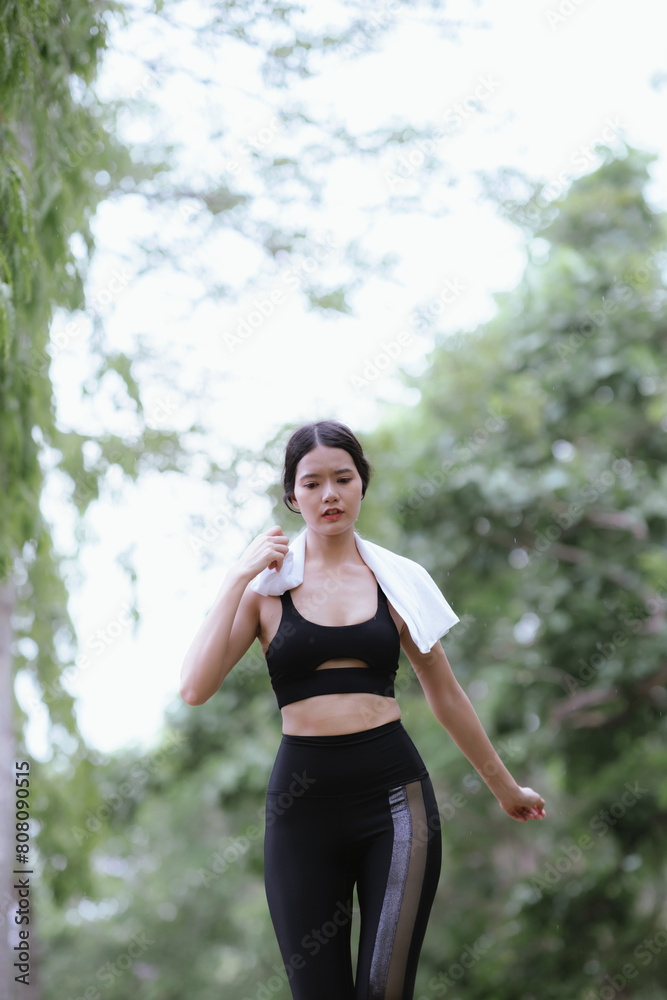Beautiful Asian female runner doing morning exercise outdoors in city park. smile happily Exercise for good health Beautiful Asian female runner doing morning exercise outdoors in city park. smile happily Exercise for good health