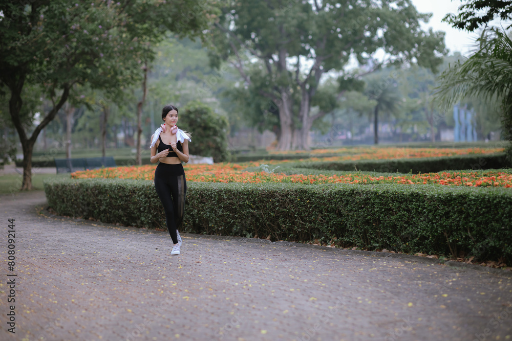 Fototapeta premium Asian woman exercising in the park Her gaze was determined to lose weight. The concept of healthy lifestyle activities