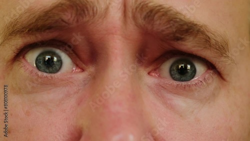 Close-up gray eyes of unhappy pleading man. A male person looking at camera feeling depression and upset. photo