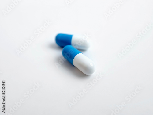 two white and blue medicine capsules close-up