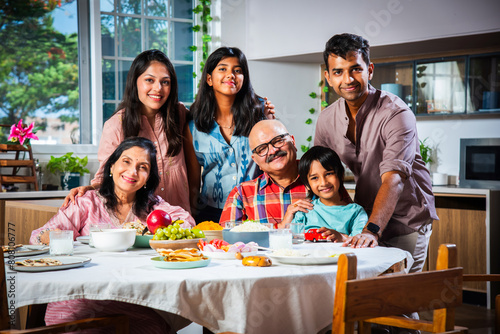 Photography Happy Indian asian family having lunch at home and posing for photo