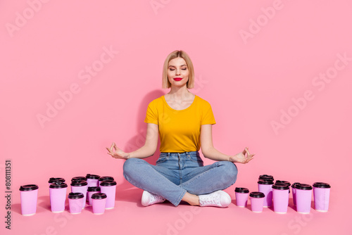 Full length photo of dreamy funny lady dressed yellow t-shirt practicing yoga trying quit coffee addiction isolated pink color background
