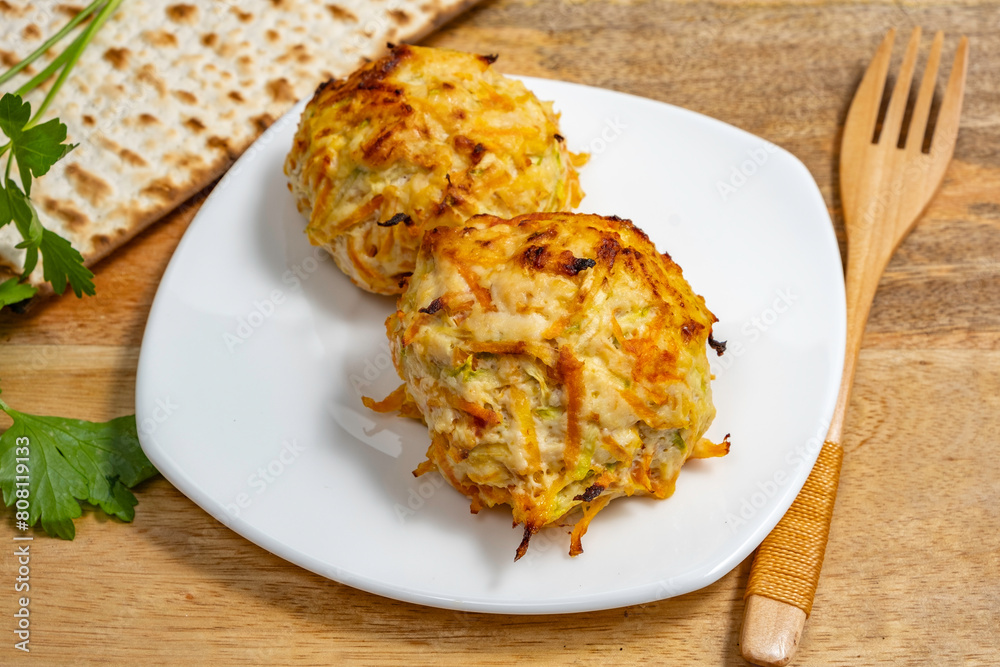 Chicken Vegetables Cutlets served with lettuce leaf, wooden cutlery, matzah piece on ceramic plate for Jewish holiday Pesach. Chicken Vegetables Cutlets served with lettuce leaf, wooden cutlery, matzah piece on ceramic plate for Jewish holiday Pesach.