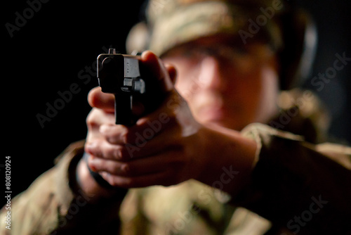close-up at a professional shooting range a military trainer in ammunition takes aim with a pistol photo