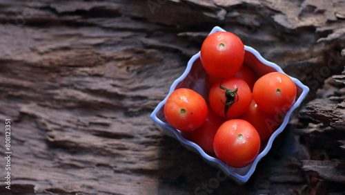 Tomatoes in a white cup on a wooden background