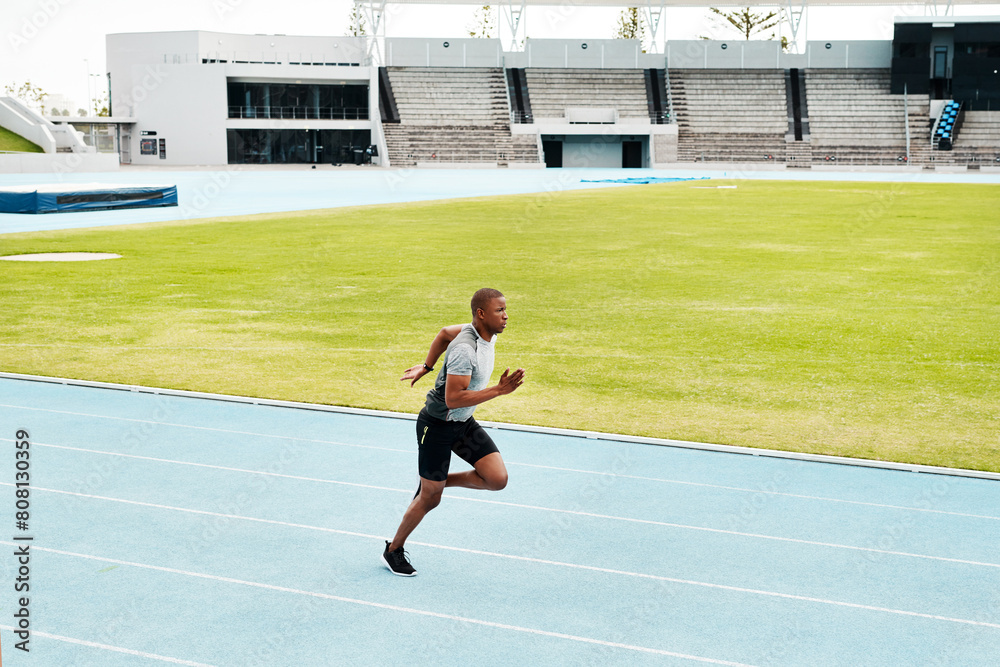 Man, stadium and running on race track for competition on field, fitness and sprint challenge or training. Athlete, exercise and development for performance, endurance or cardio workout for wellness