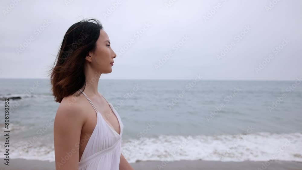 Attractive Asian woman in a white dress walking on the beach in Santa Monica California. Slow Motion. Attractive Asian woman in a white dress walking on the beach in Santa Monica California. Slow Motion.