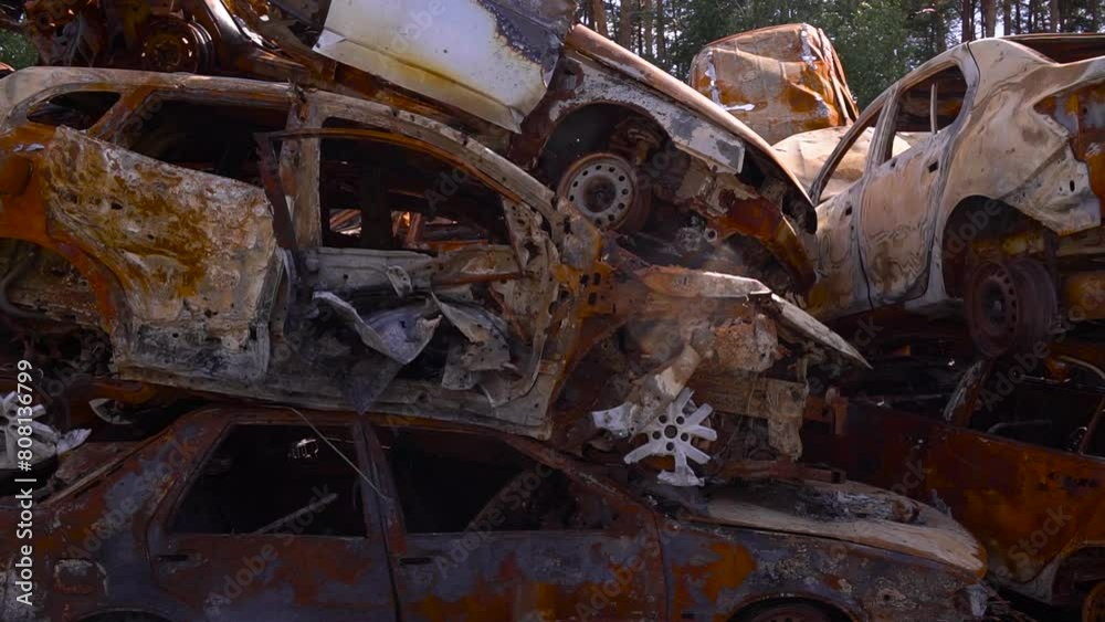 Pile of rusted vehicles stacked on soil near tree Pile of rusted vehicles stacked on soil near tree