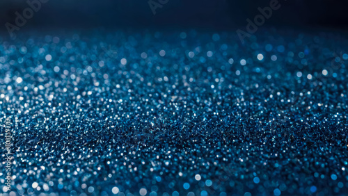 Festive background made of scattering of decorative blue particles. Shiny glass or stone small crystal elements with bokeh. Perfect abstract backdrop.