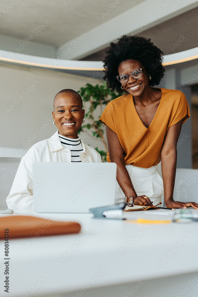 Obraz premium Two business women collaborating on a creative design project in a professional office