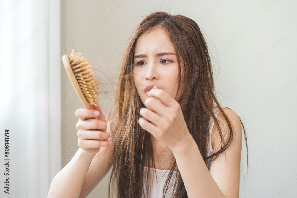 Damaged hair, amazed asian young woman, girl hand holding brush comb, hairbrush with fall hair from scalp after brushing, face worry about balding. Health care, beauty treatment, hair loss problem. Damaged hair, amazed asian young woman, girl hand holding brush comb, hairbrush with fall hair from scalp after brushing, face worry about balding. Health care, beauty treatment, hair loss problem.
