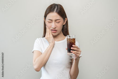 Health asian young woman touching her mouth, expression, suffering from toothache, decay or sensitivity cavity molar tooth or inflammation drink cold, sparkling water at home.Sensitive teeth people.