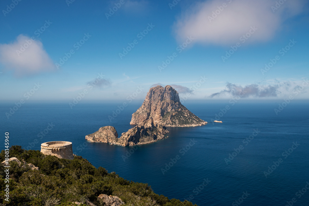 Fototapeta premium Es Vedrà island and Torre Des Savinar watchtower view, in the municipalityof Sant Josep de Sa Talaia, Ibiza, Balearic Islands, Spain