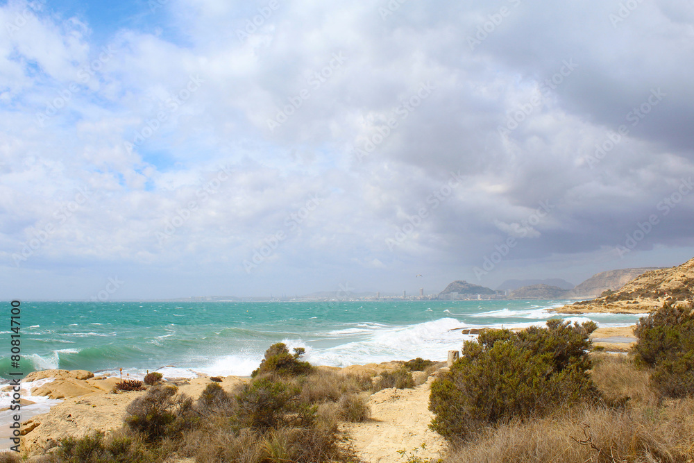 beach and sea, cloudy sky over sea and rocks,sea waves breaking against the rocks beach and sea, cloudy sky over sea and rocks,sea waves breaking against the rocks