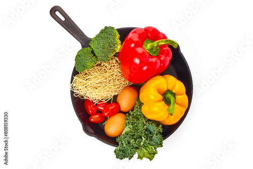 Vegetables with egg Noodles on a cast iron frying pan, isolated on white background photo