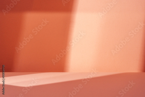 Empty table on salmon color background with natural shadow on the wall. Mock up for food, branding products, presentation, perfumes or health care..