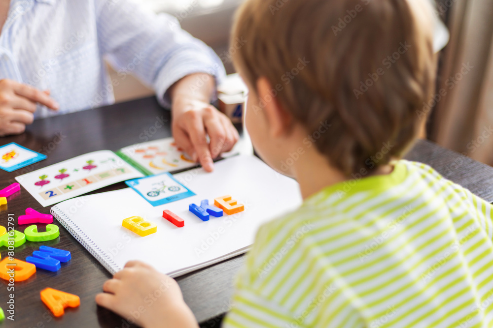 Child Learning Letters with Colorful Magnets Child Learning Letters with Colorful Magnets