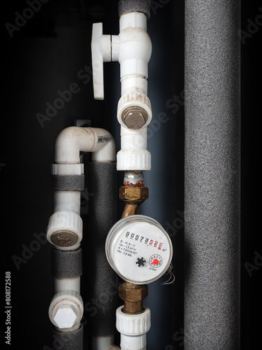 Water meter in box with pipes built into the wall . Water consumption measuring device