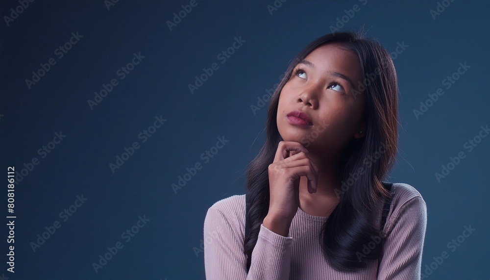 Young woman isolated on background having doubts while looking up Young woman isolated on background having doubts while looking up