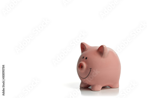 Smiling, pink piggy bank isolated on a white background; concept image ceramic piggy bank representing saving, economy, cost of living with copy space.