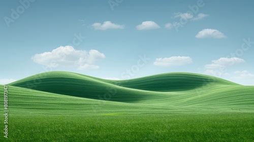  A landscape of emerald green grass stretches out, framed by a cerulean blue sky overhead Scattered clouds dot the expanse above