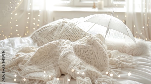   An open umbrella placed next to a bed, with a blanket on top photo