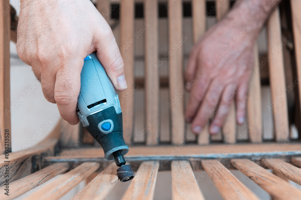Close-up of a Man Sanding Wooden Furniture Outdoors Close-up of a Man Sanding Wooden Furniture Outdoors